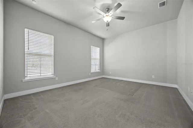 an empty room with a window and a fan