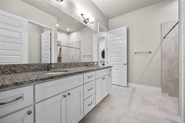 a bathroom with a granite countertop sink two mirror and a