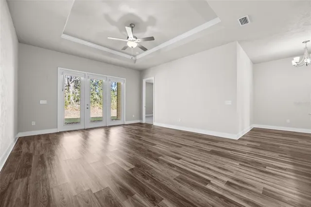 a view of an empty room with wooden floor and window