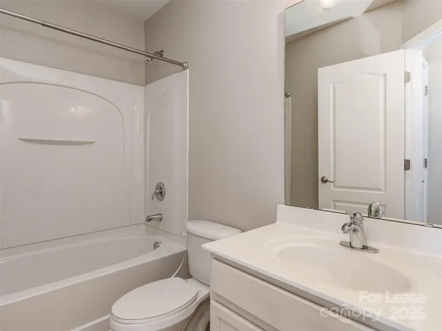 a view of a hallway with wooden floor and a living room