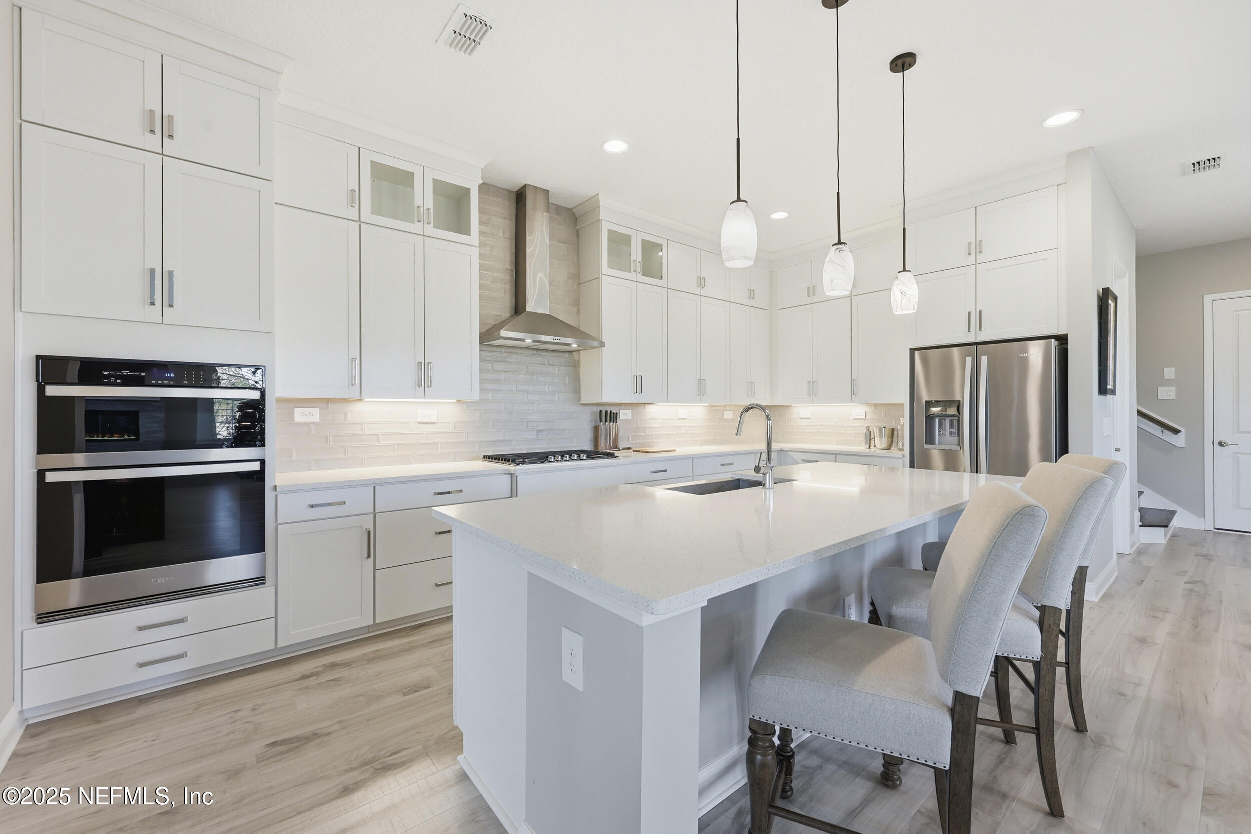 45 Rum Runner Way St. Johns, FL 32259 - Photo 11 of 50 a kitchen with stainless steel appliances granite countertop a stove a sink a oven a kitchen island with white cabinets and wooden floor