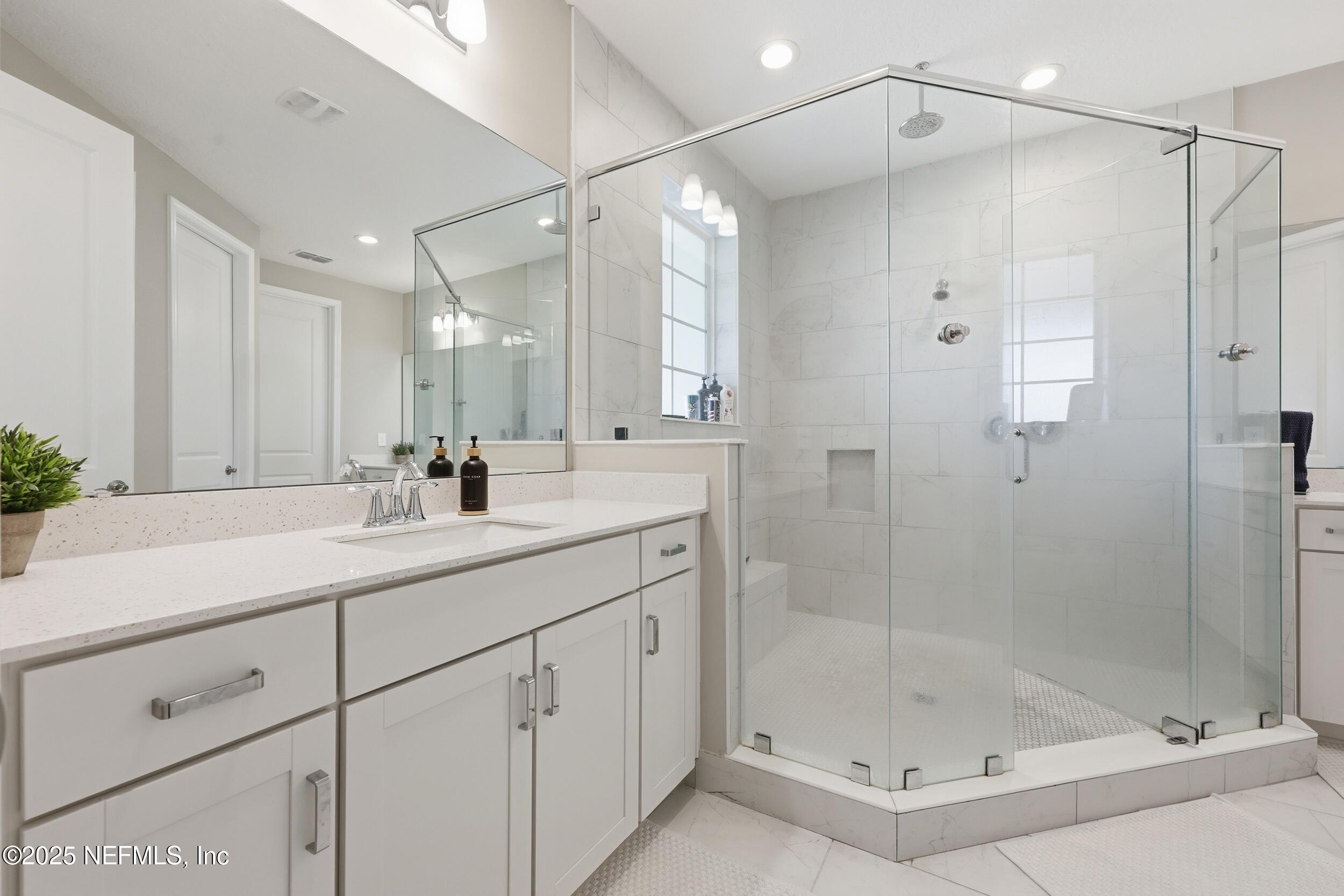 45 Rum Runner Way St. Johns, FL 32259 - Photo 18 of 50 a bathroom with a shower sink and mirror