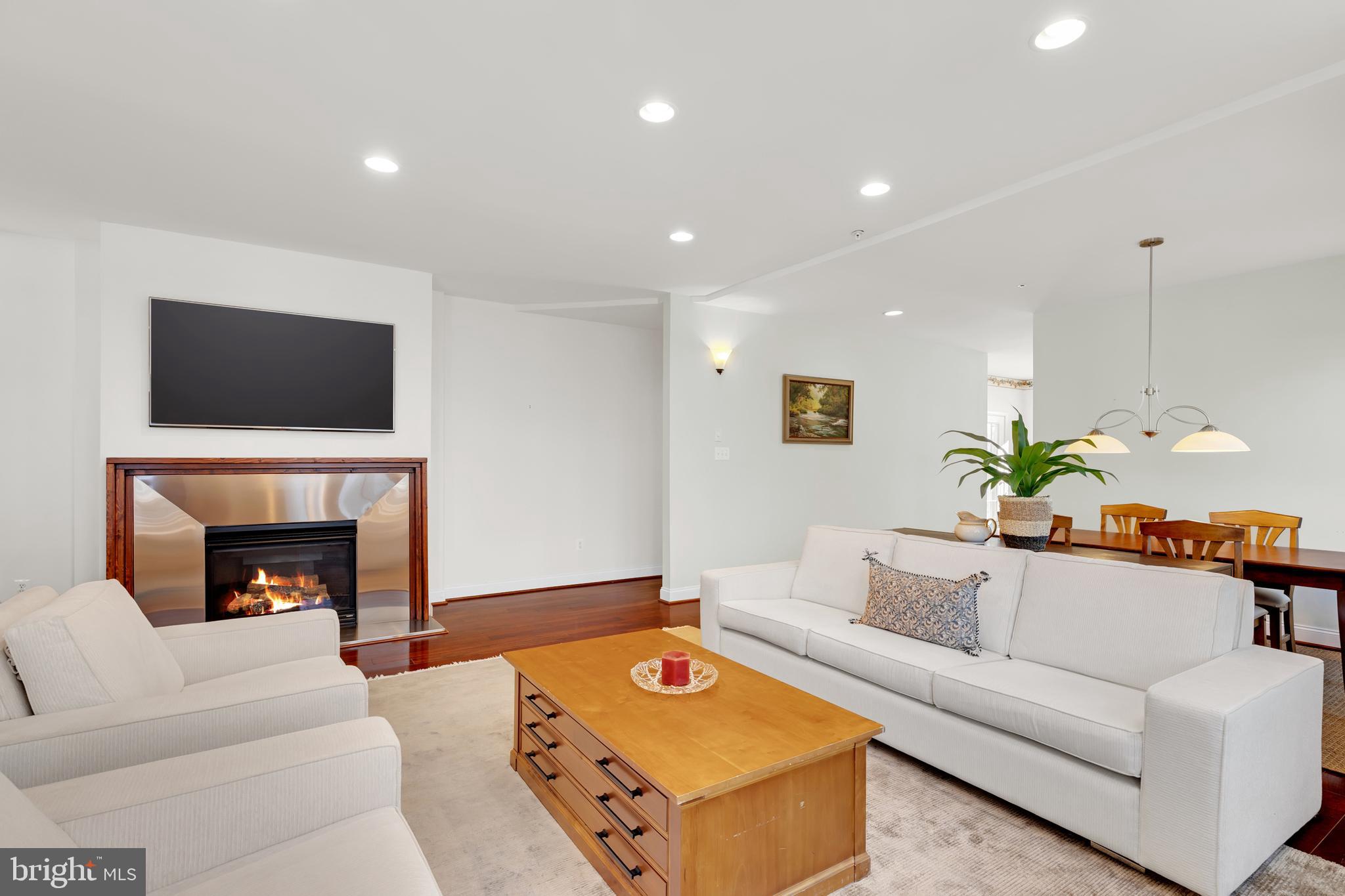 8781 Endless Ocean Way, Unit 58 Columbia, MD 21045 - Photo 14 of 74 a living room with furniture a fireplace and a flat screen tv