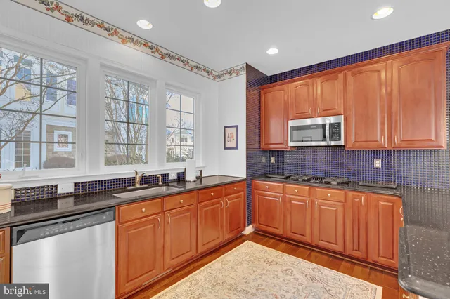 a kitchen with stainless steel appliances granite countertop wooden cabinets a sink and dishwasher