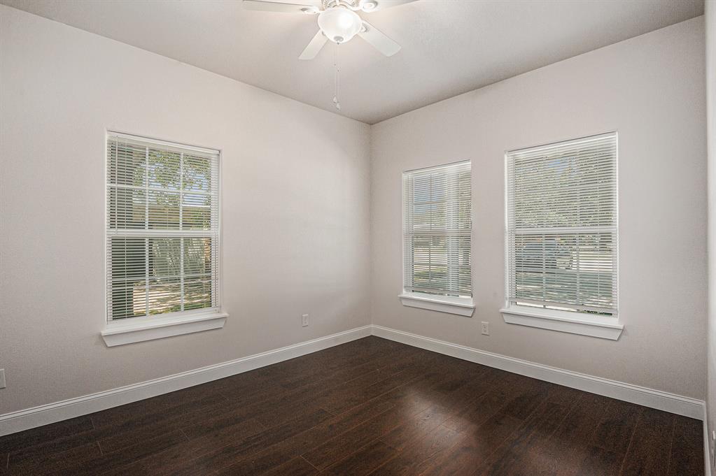 290 Aurora Street Rhome, TX 76078 - Photo 13 of 17 an empty room with wooden floor and windows