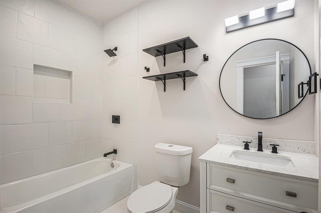290 Aurora Street Rhome, TX 76078 - Photo 14 of 17 a bathroom with a toilet sink vanity tub and mirror