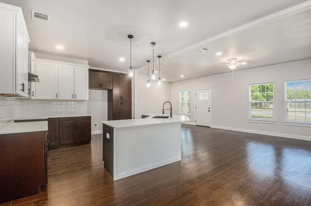 a kitchen with stainless steel appliances granite countertop a sink a stove and a refrigerator