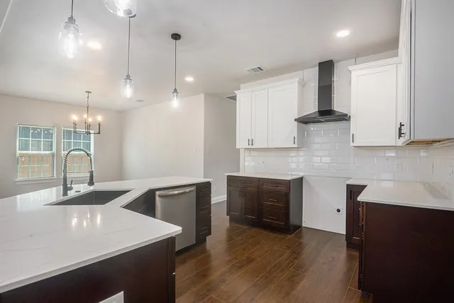 an empty room with wooden floor chandelier fan and windows