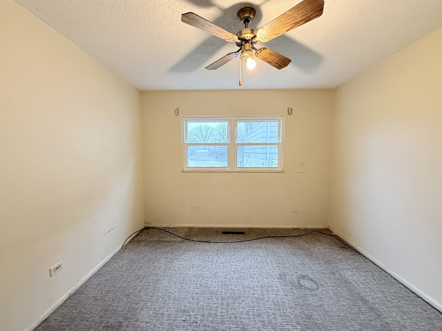 196 Green Court Streamwood, IL 60107 - Photo 11 of 18 an empty room with a chandelier fan and windows