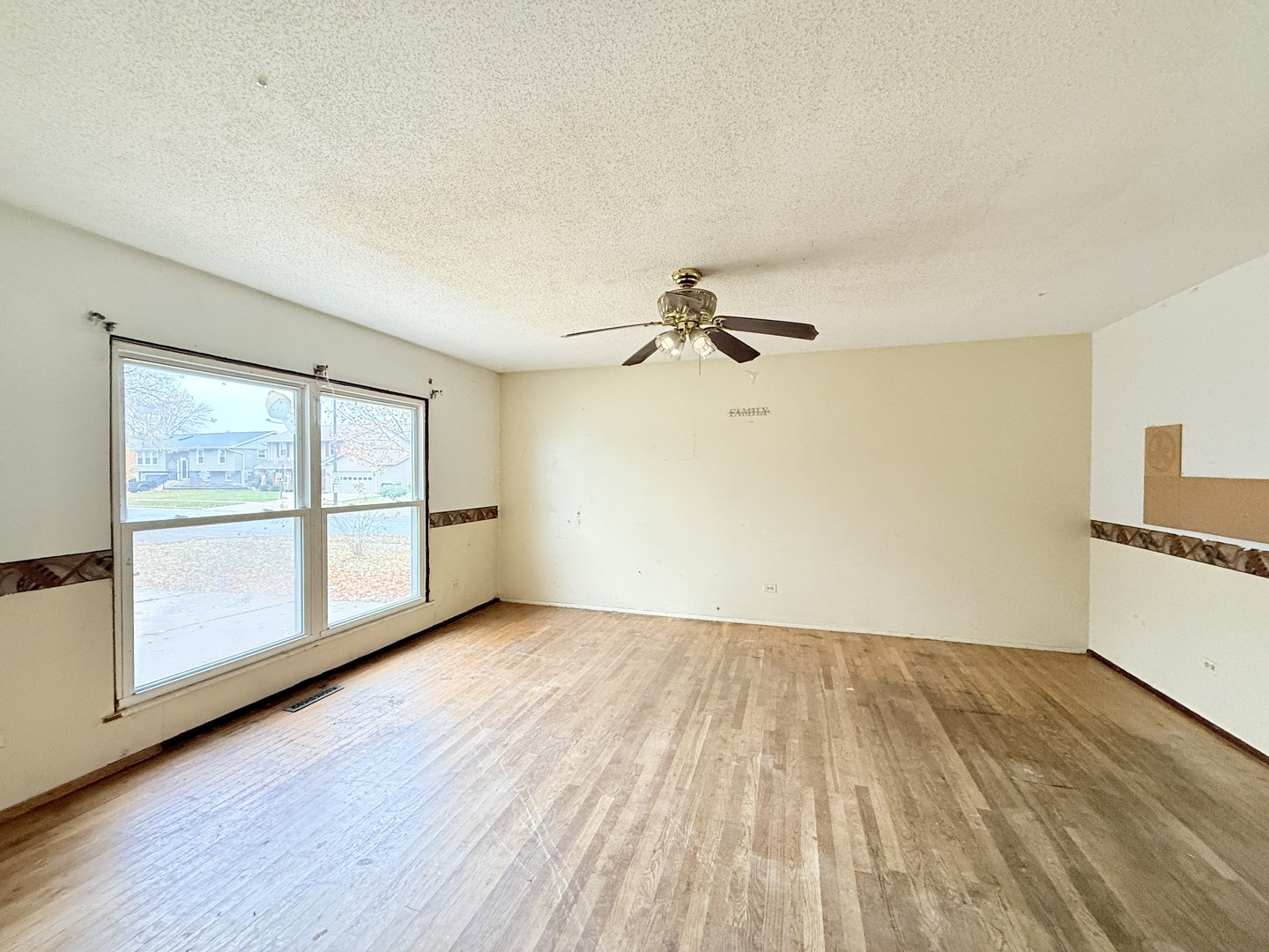 196 Green Court Streamwood, IL 60107 - Photo 2 of 18 a view of empty room with wooden floor and fan