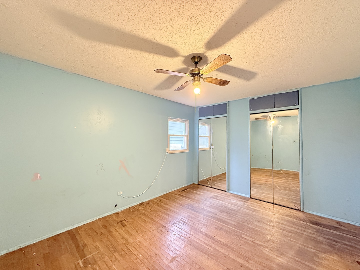 196 Green Court Streamwood, IL 60107 - Photo 7 of 18 an empty room with a ceiling fan and wooden floor