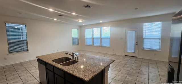 a kitchen with granite countertop a sink and a stove