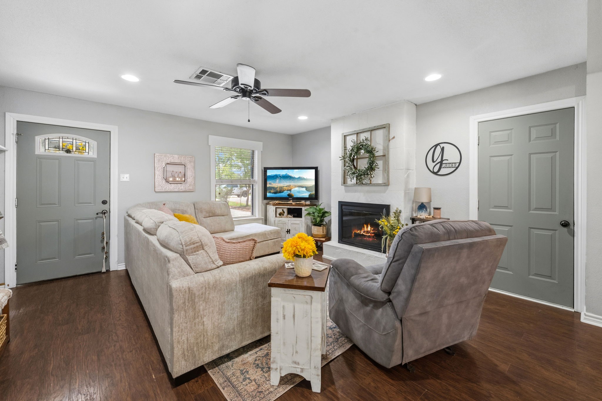 431 Corydon Drive Houston, TX 77336 - Photo 5 of 26 Warm and inviting family room featuring laminate wood floors, a charming fireplace, and a large window that fills the space with natural light, creating a comfortable and cozy atmosphere.