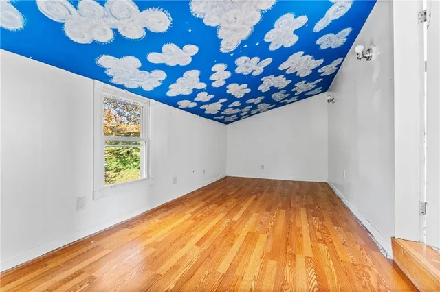 a view of a room with wooden floor and window