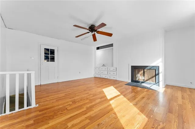 a view of a room with wooden floor and a ceiling fan