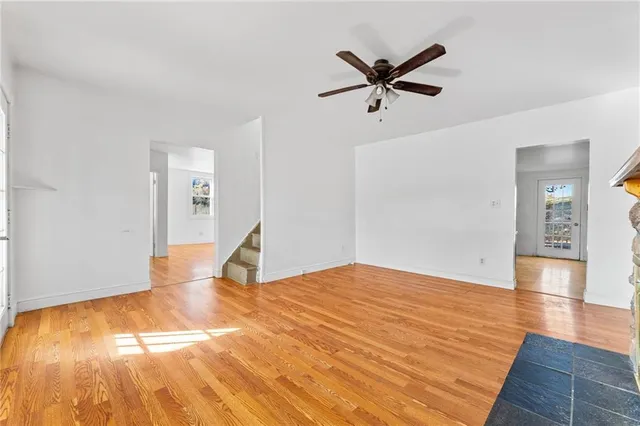 a view of a room with wooden floor and a ceiling fan
