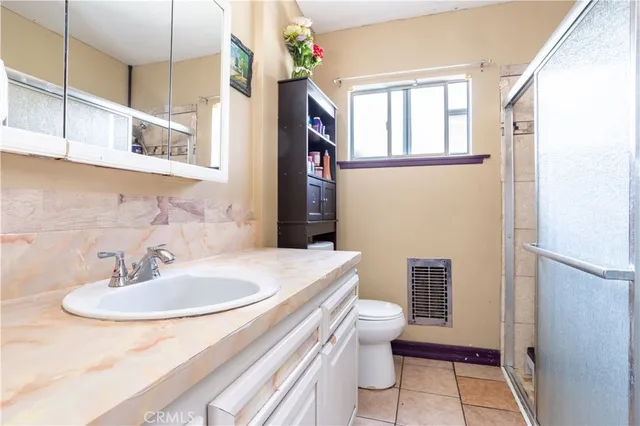 a bedroom with a bed and a flat tv screen on dresser