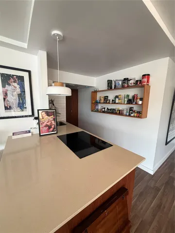 a kitchen with stainless steel appliances a stove a refrigerator a chimney and wooden floor