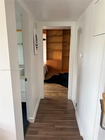 a view of a hallway with wooden floor and closet