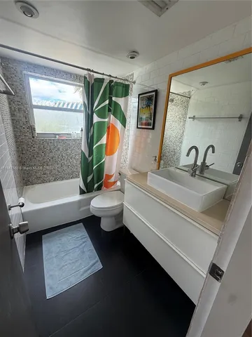 a bathroom with a tub sink toilet and mirror