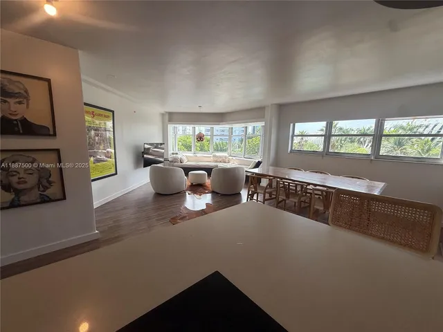 a kitchen with a large window and a view of living room