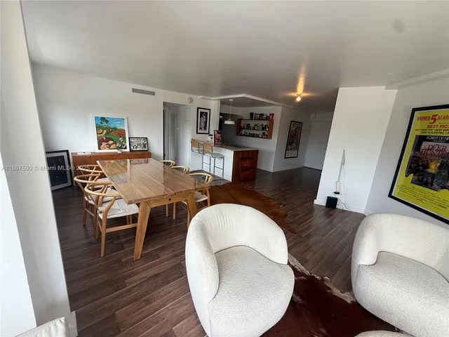 a living room with dining room and wooden floor