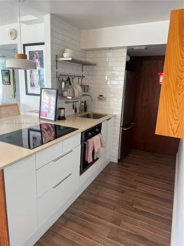 a kitchen with stainless steel appliances granite countertop a sink stove and wooden floor