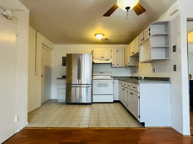 a kitchen with a sink cabinets stainless steel appliances and a window
