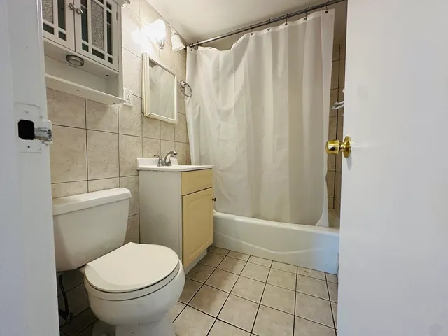 a bathroom with a sink a toilet a window and shower