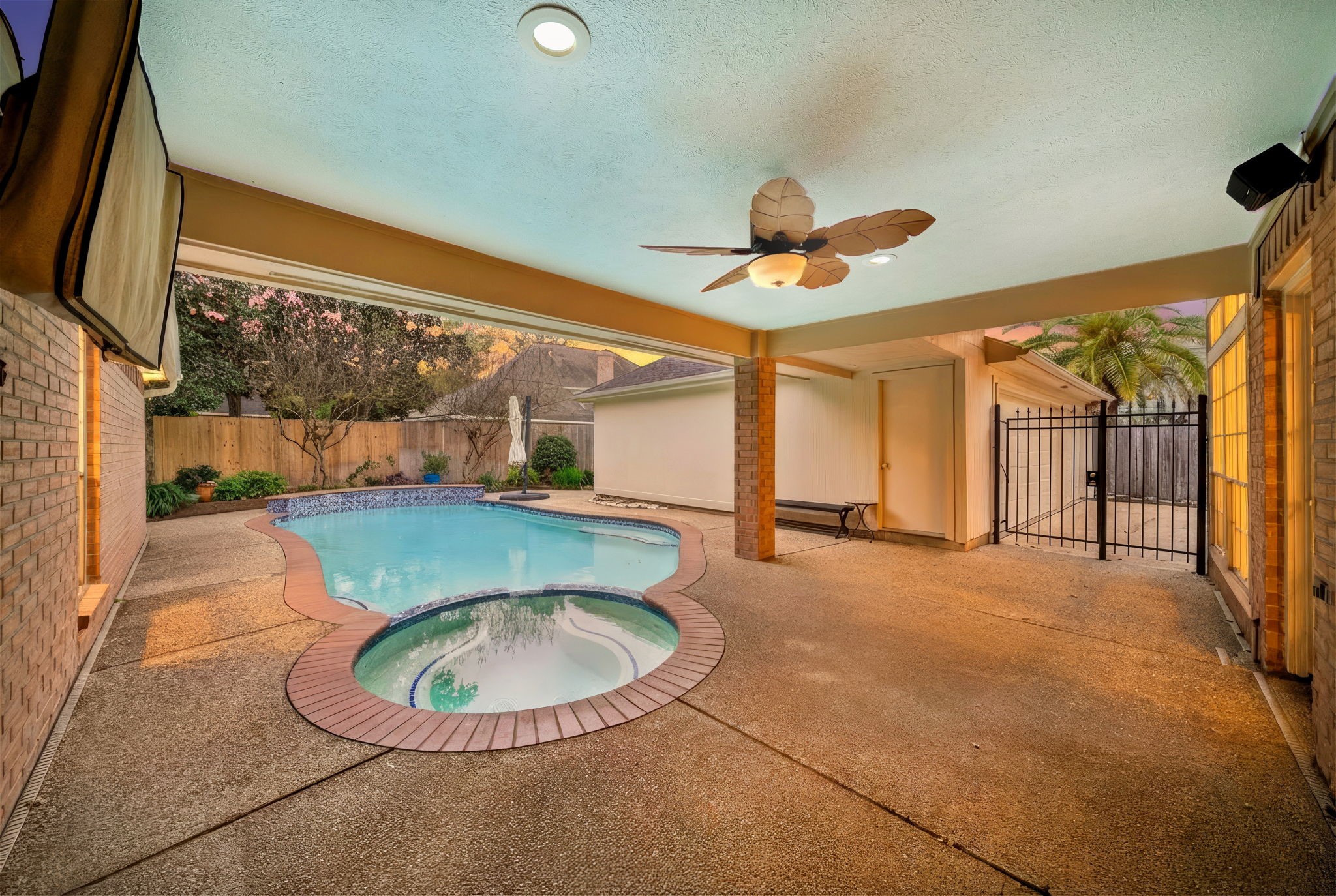 2114 Lytham Lane Katy, TX 77450 - Photo 22 of 29 Covered patio area with a ceiling fan, overlooking a backyard pool and spa ideal for relaxation and entertainment.