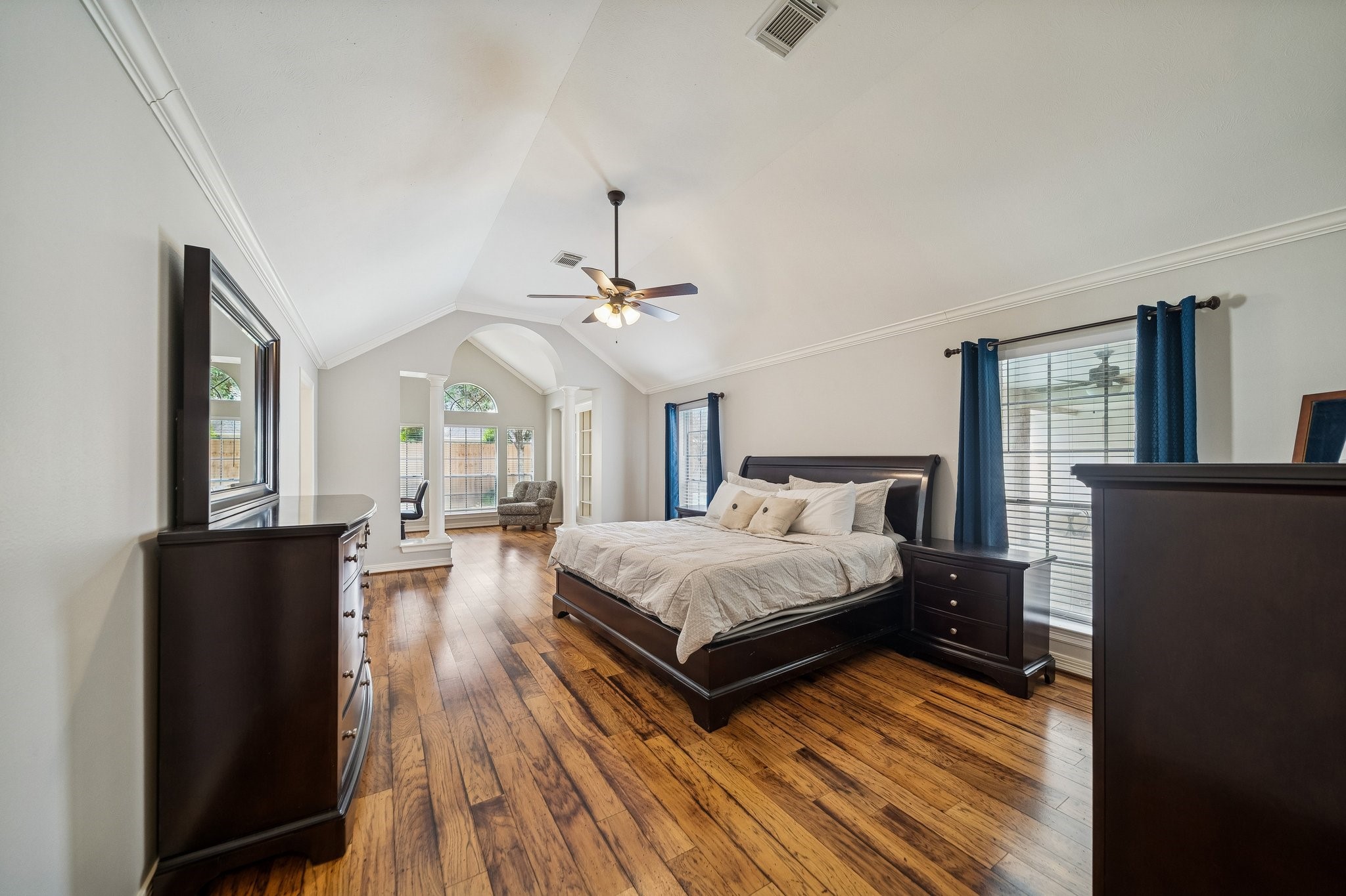 2114 Lytham Lane Katy, TX 77450 - Photo 10 of 29 This spacious bedroom features a vaulted ceiling and engineered hardwood floors, with large windows allowing ample natural light. It includes an private study/sitting area, and neutral walls, creating a serene and inviting atmosphere.