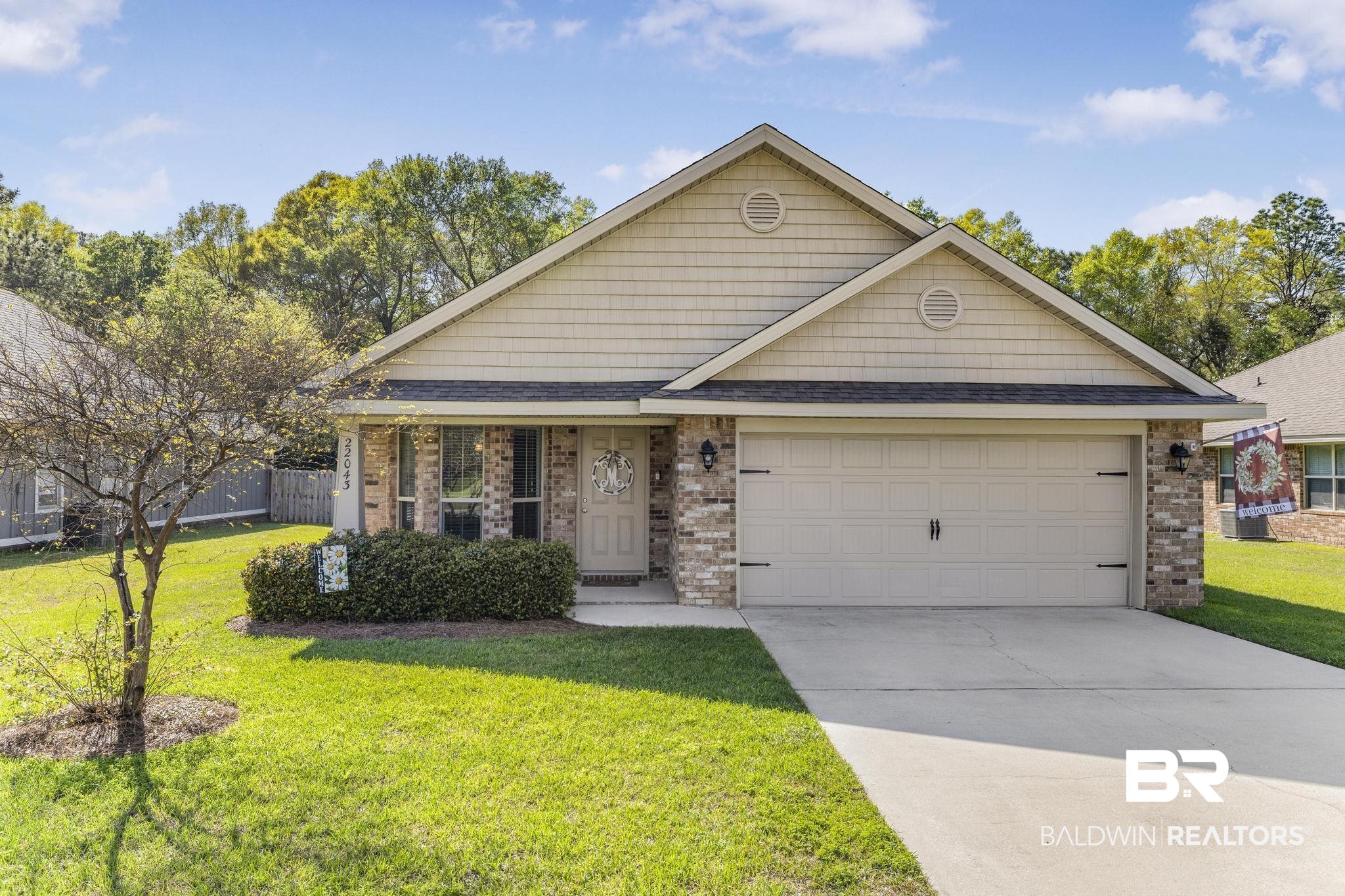22043 Garland Loop Silverhill, AL 36576 - Photo 2 of 41 View of front of property featuring a shingled roof, a front lawn, concrete driveway, and brick siding