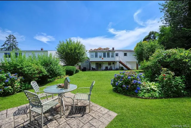 a view of a house with a yard and sitting area
