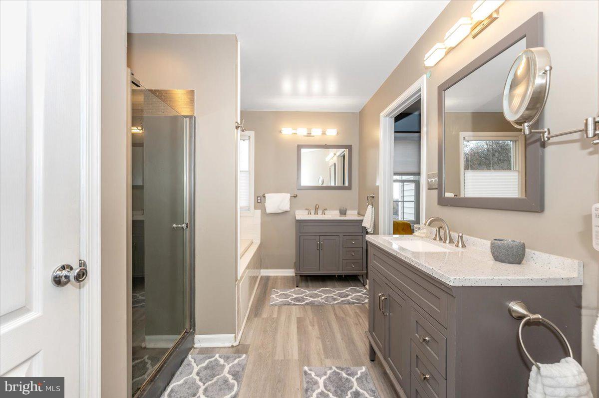 6536 South Clifton Road Frederick, MD 21703 - Photo 34 of 71 a bathroom with a double vanity sink a mirror and a bathtub