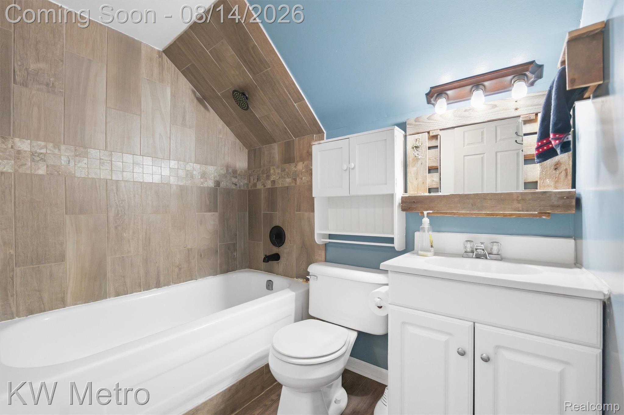 201 South Maple Leaf Road Lapeer, MI 48446 - Photo 27 of 70 White bathtub with tiled surround featuring a decorative mosaic band