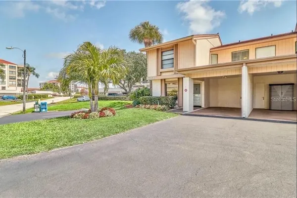 a front view of a house with a yard and trees