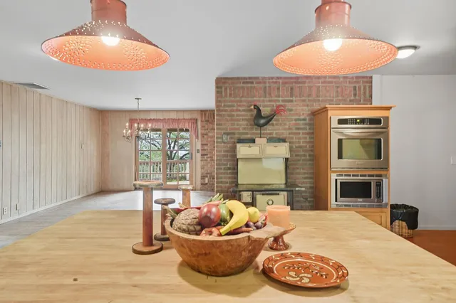 a view of a livingroom with furniture wooden floor fireplace and windows