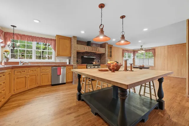 a kitchen with stainless steel appliances kitchen island granite countertop a stove a sink and a refrigerator