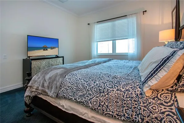 a spacious bedroom with a bed and a flat screen tv