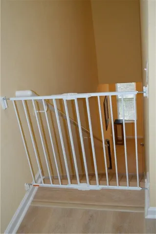 a view of staircase with railing and white walls