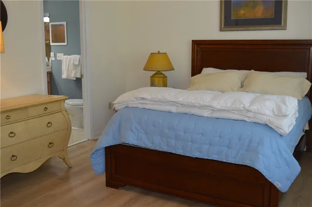 a bedroom with a bed and a lamp on dresser