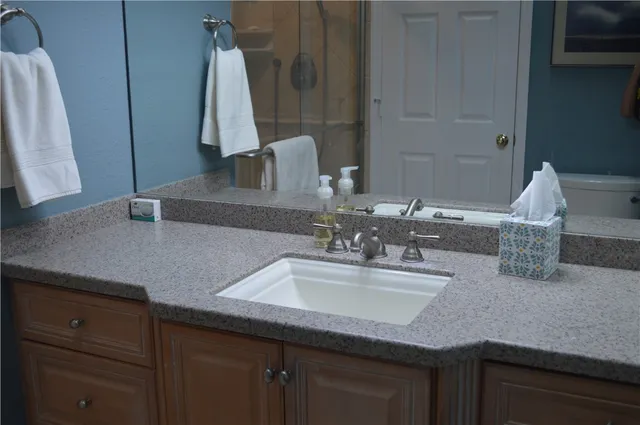 a bathroom with a granite countertop sink and a mirror