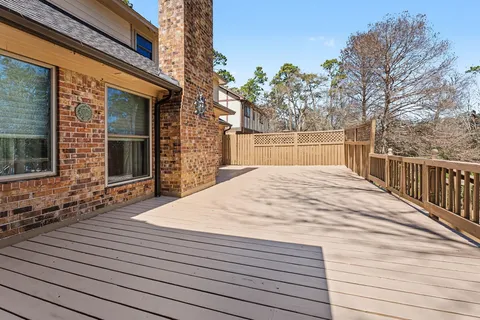 a view of balcony with wooden floor and fence