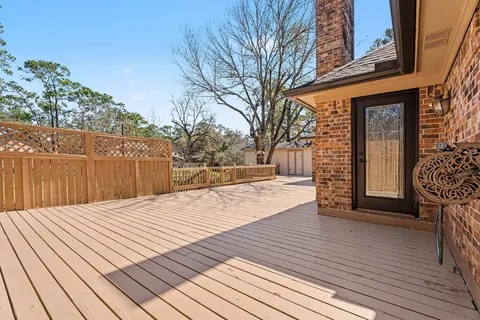 a view of a house with wooden deck front of house