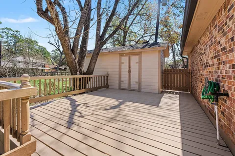 a view of a roof deck with couches with wooden floor and fence