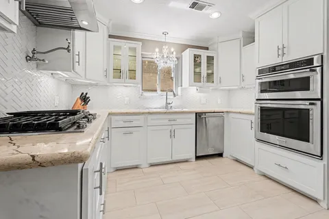 a kitchen with appliances a refrigerator and cabinets