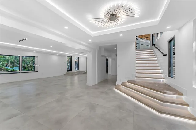 a large kitchen with a large counter top space a sink stainless steel appliances and cabinets