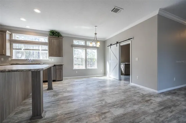 a kitchen with stainless steel appliances granite countertop a stove top oven a refrigerator and a sink with granite countertops