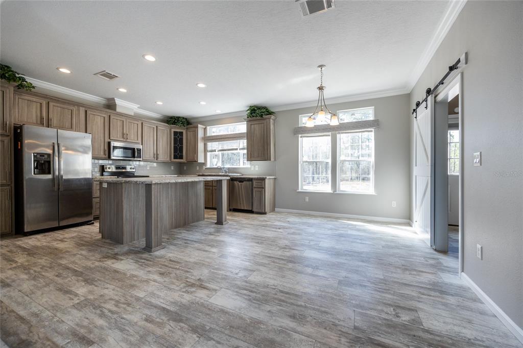 6671 Southwest 128th Lane Lake Butler, FL 32054 - Photo 15 of 66 a kitchen with stainless steel appliances granite countertop a stove top oven a refrigerator and a sink with granite countertops