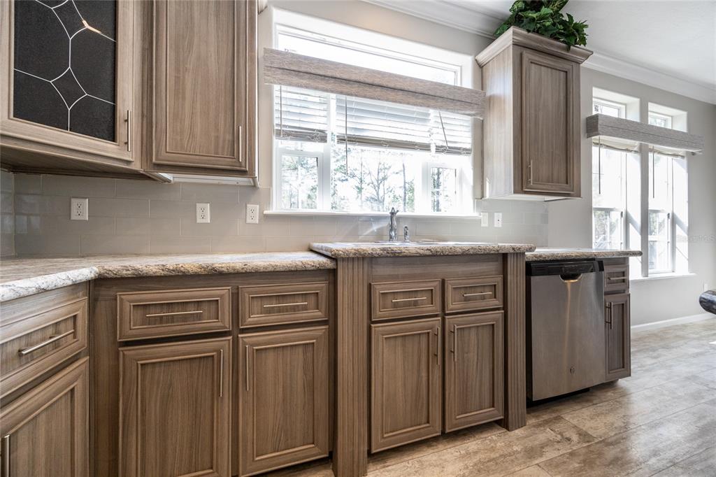 6671 Southwest 128th Lane Lake Butler, FL 32054 - Photo 19 of 66 a kitchen with stainless steel appliances granite countertop a sink and dishwasher with wooden cabinets
